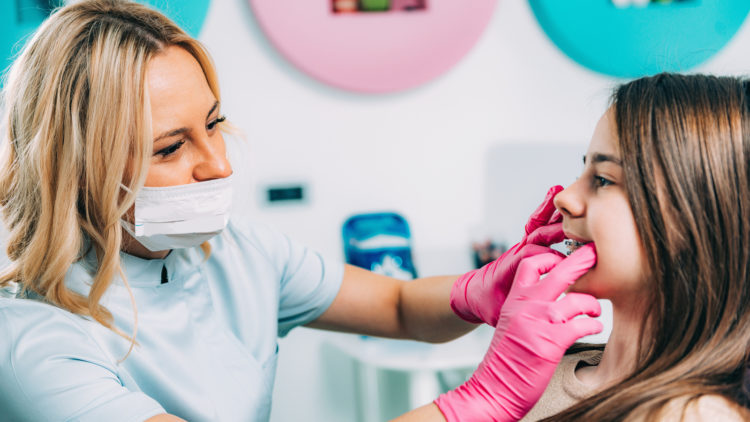 Orthodontist examining teen