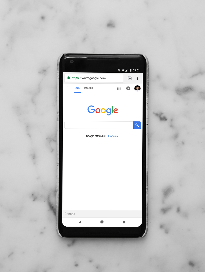 The Google homepage is displayed on an iPhone that is on a marble counter.