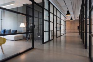 A photo of an office hallway with glass walls.