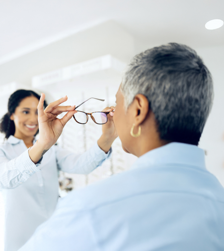 Technician Helping Patient Trying On Eye Glasses